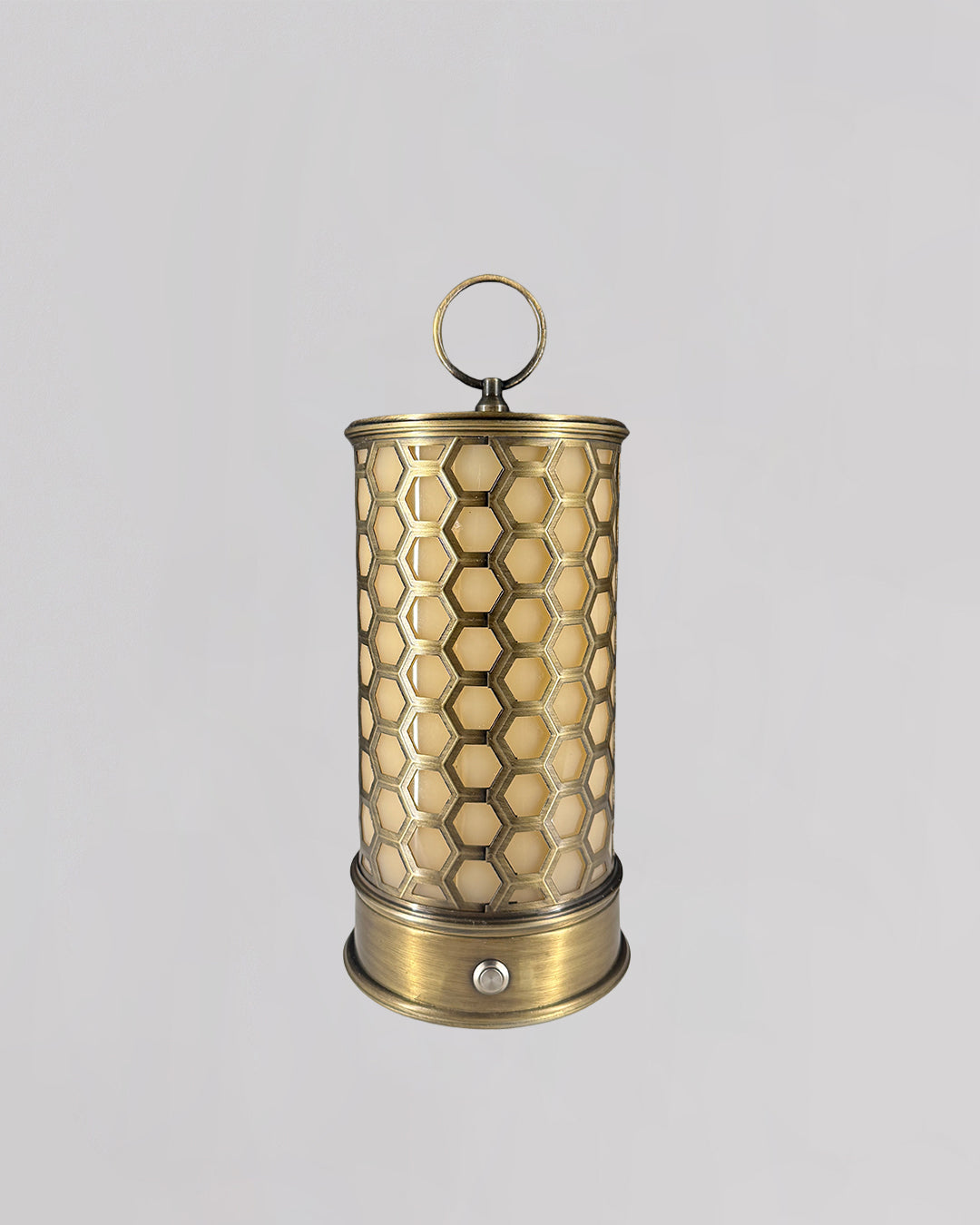 Brass candle holder with honeycomb pattern on a light gray background