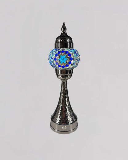 Decorative lamp with a metallic base and colorful glass top on a gray background