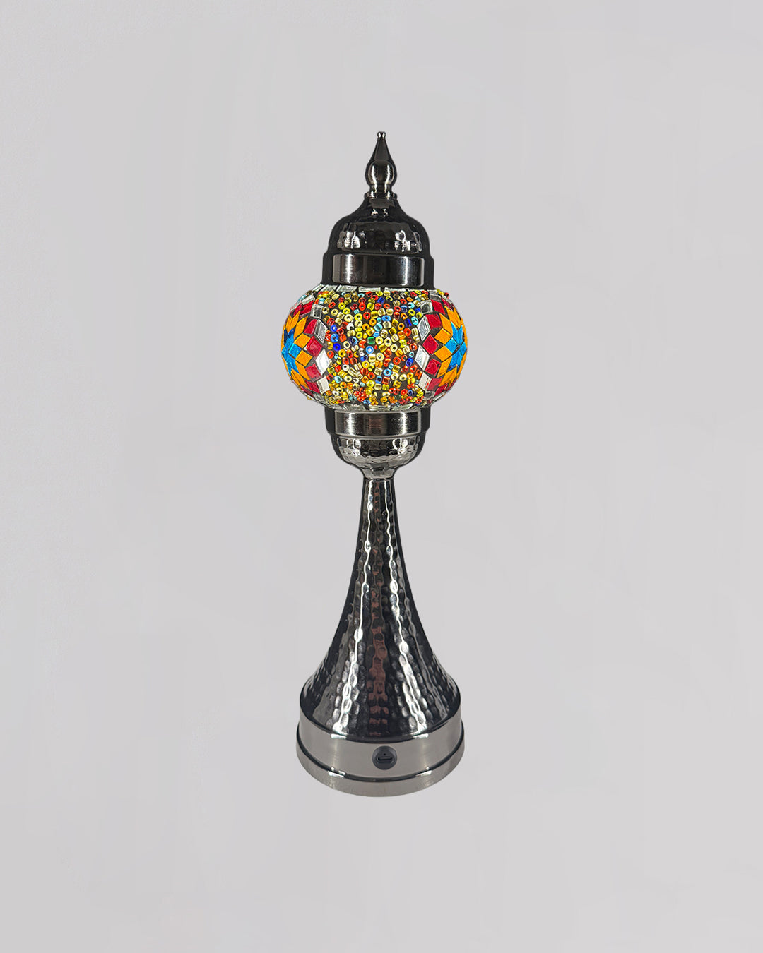 Decorative lamp with colorful glass shade and metallic base on a light gray background