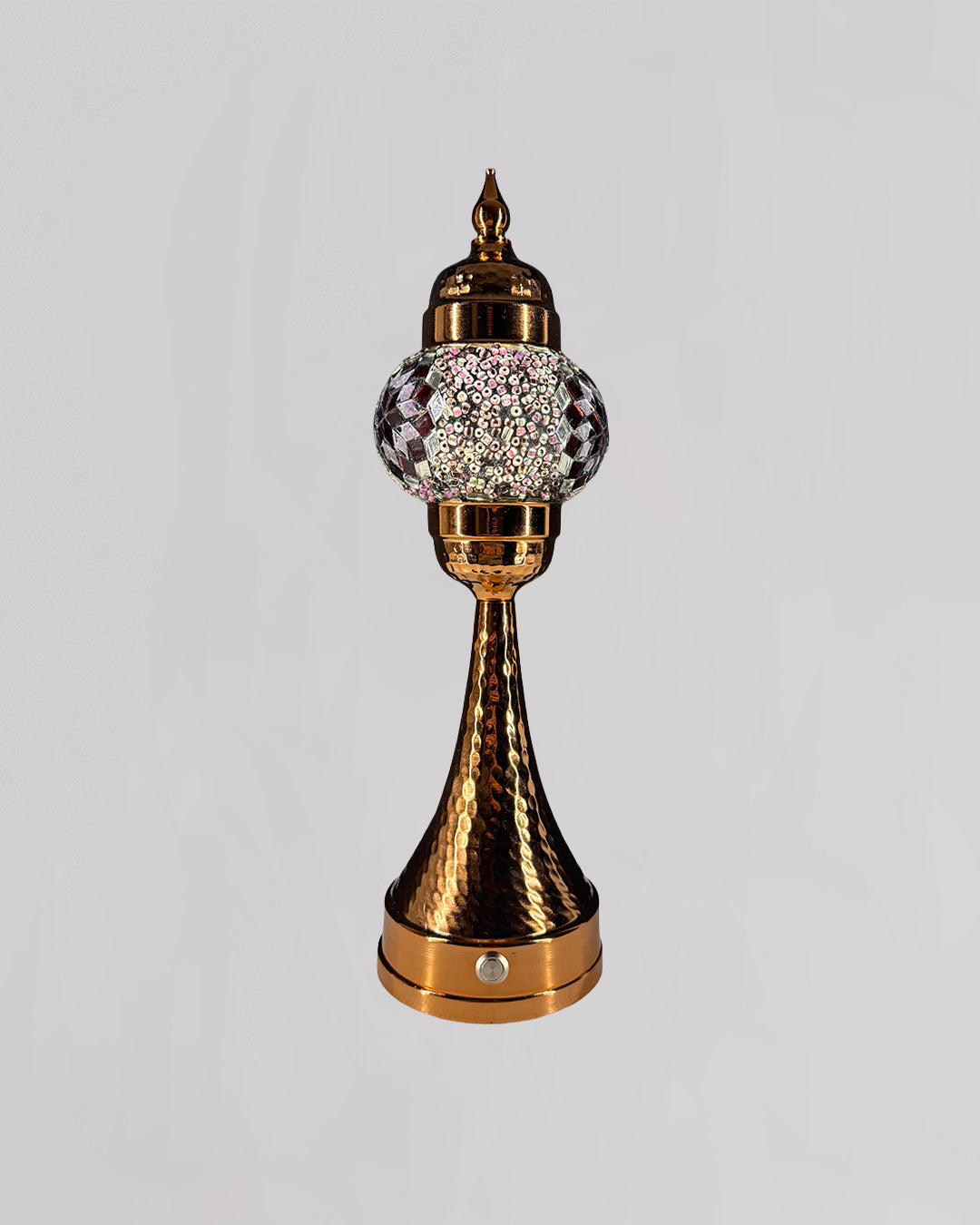 Decorative object with gold and crystal design on a light gray background