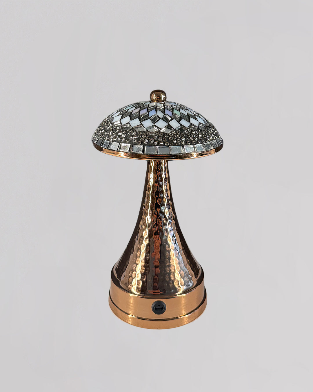 Decorative lamp with a metallic finish on a light gray background