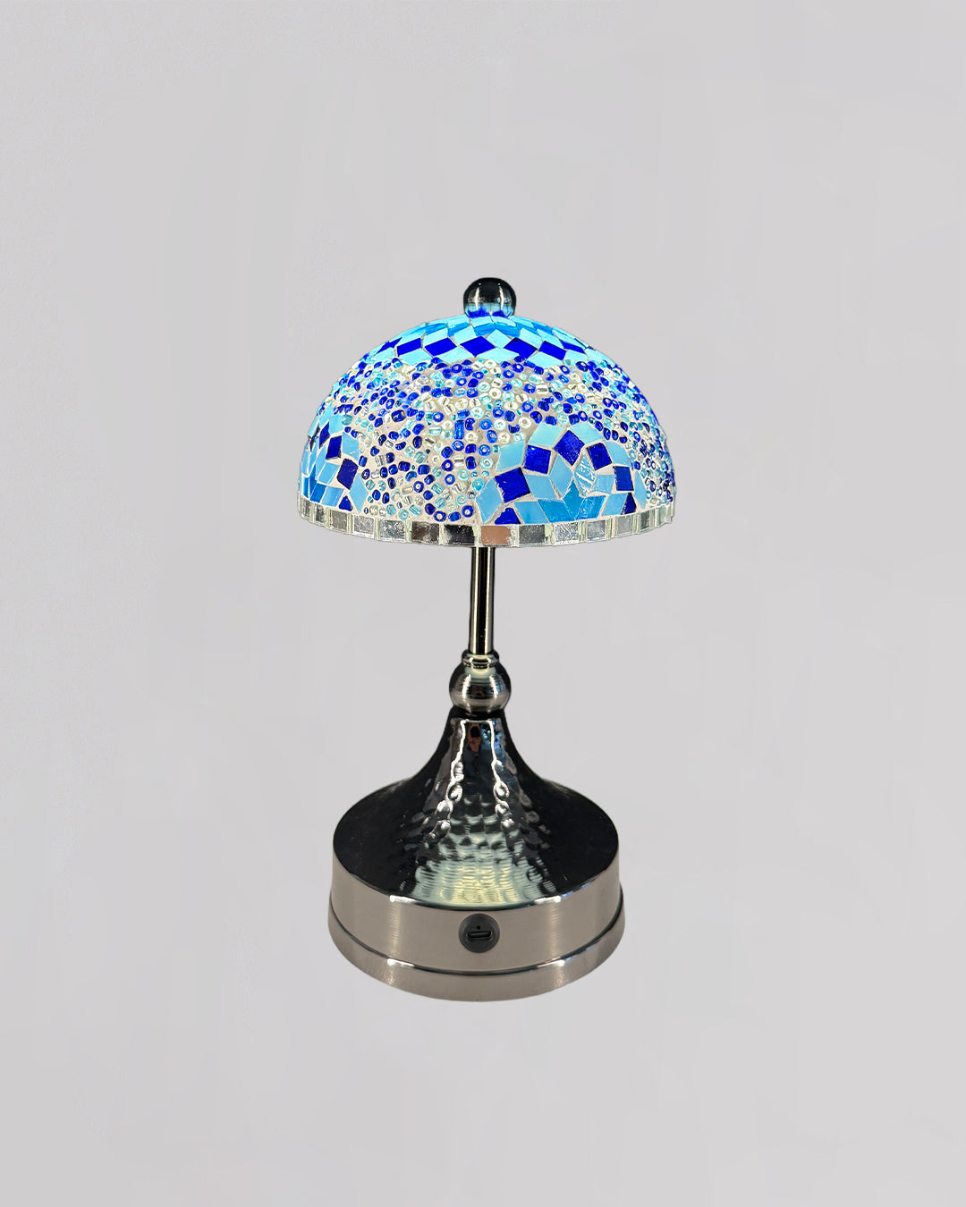 Table lamp with a mosaic blue glass shade on a gray background